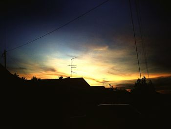 Low angle view of silhouette built structure against sky at sunset