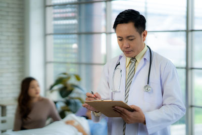 Portrait of doctor examining patient in office