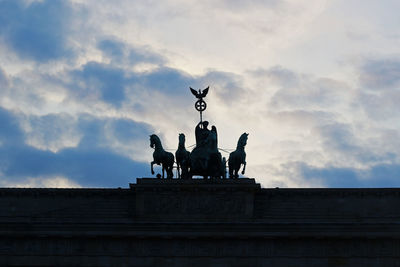 Low angle view of statue against cloudy sky