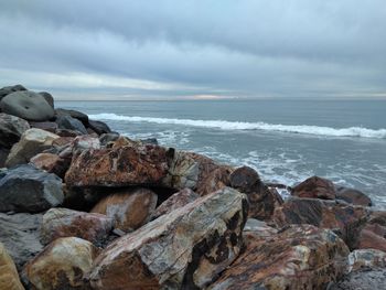 Rocks on beach against sky