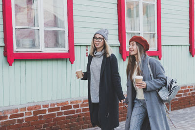 Portrait of smiling couple standing against wall