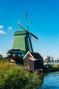 Traditional windmill by building against sky