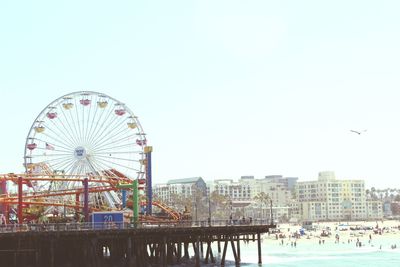 Ferris wheel in city against clear sky