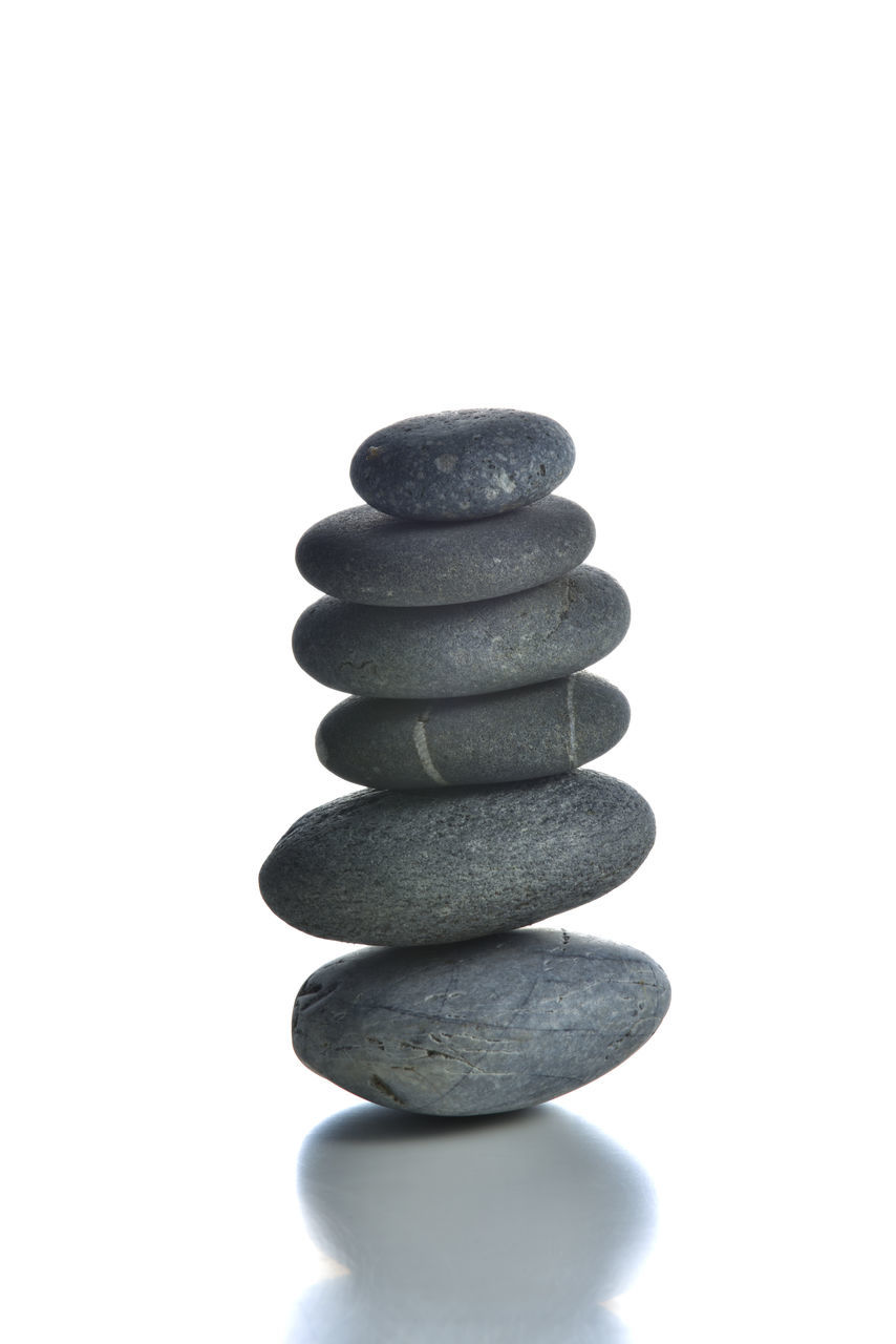 STACK OF ROCKS AGAINST SKY OVER WHITE BACKGROUND