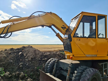 Big yellow excavator on an agriculural field