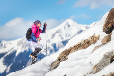 People on snowcapped mountain against sky