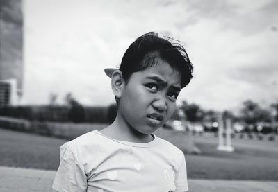 Portrait of boy standing against sky