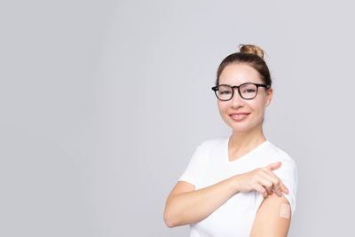 Woman and white t-shirt with a patch on hand rejoices from receiving a vaccination coronavirus 