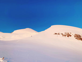 Scenic view of snowcapped mountains against clear blue sky