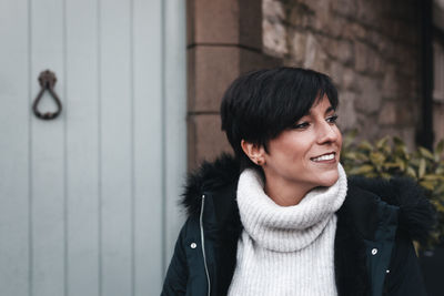 Portrait of smiling young woman standing in winter