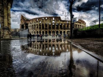 Reflection of people on puddle in city