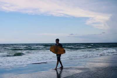 Rear view of man standing on beach