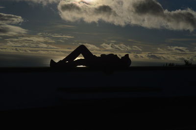 Silhouette boat in sea against sky during sunset