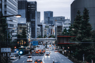 Traffic on city street and buildings at dusk