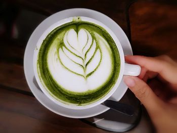 Cropped image of hand holding coffee cup