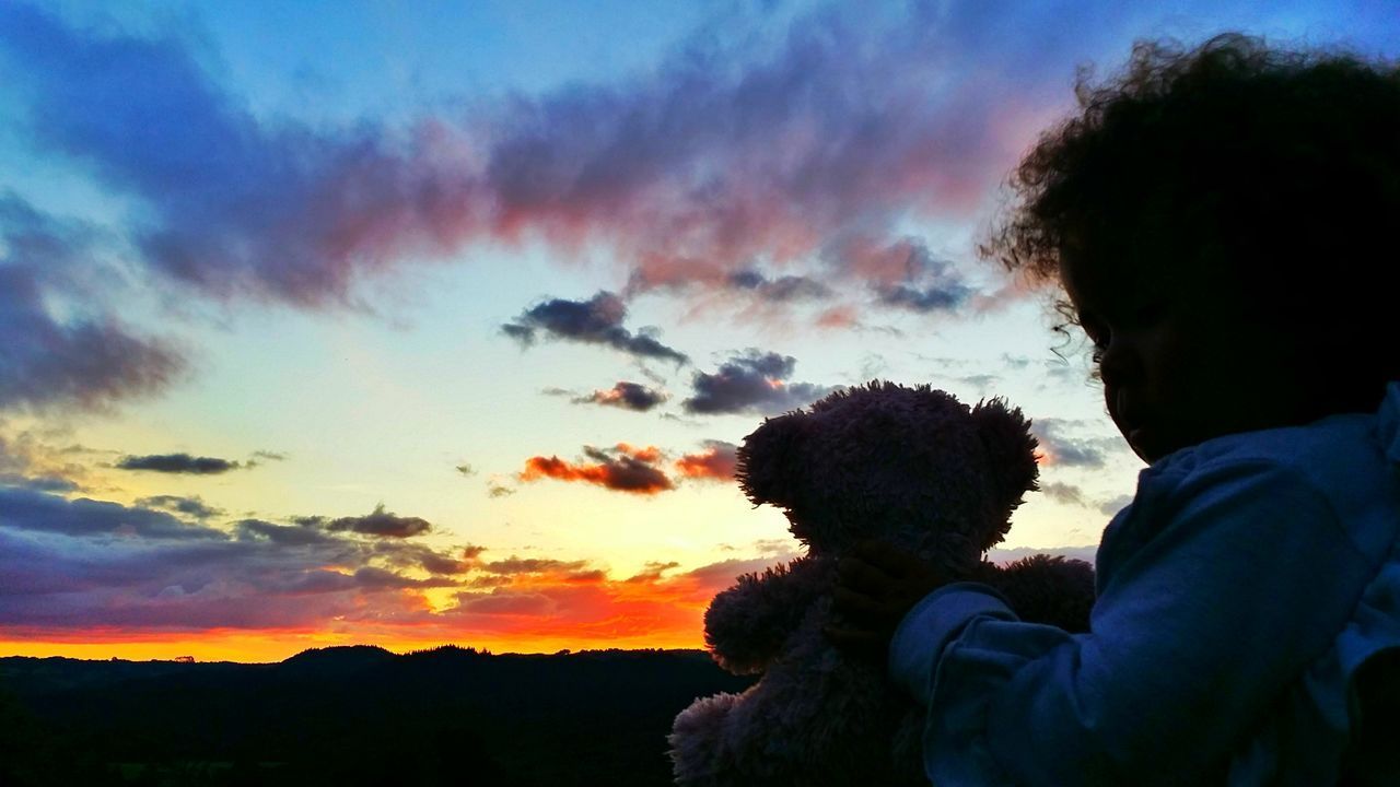 SILHOUETTE FRIENDS AND SON AGAINST SKY DURING SUNSET