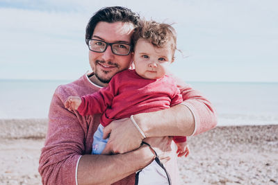 Portrait of father and daughter on beach