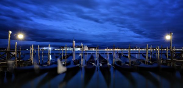 Sailboats moored in marina at night