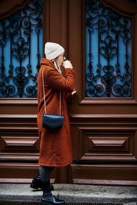 Woman with coffe near door