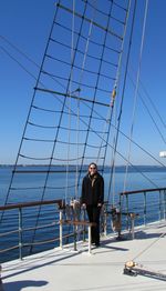 Portrait of woman standing in boat on sea against clear sky