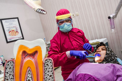 Dentist using mask and protection wear during covid-19 pandemic