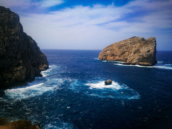 Scenic view of rocks in sea against sky