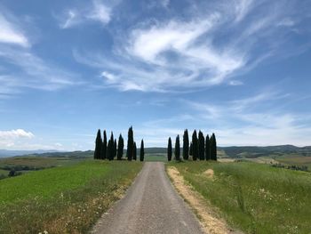 Road amidst field against sky