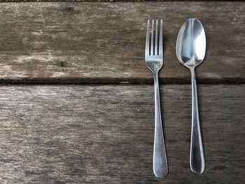 Directly above shot of fork and spoon on wooden table
