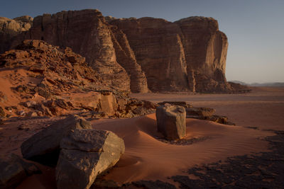 Rock formations on shore against sky