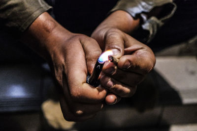 Midsection of man holding cigarette