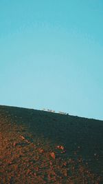 Low angle view of land against clear blue sky