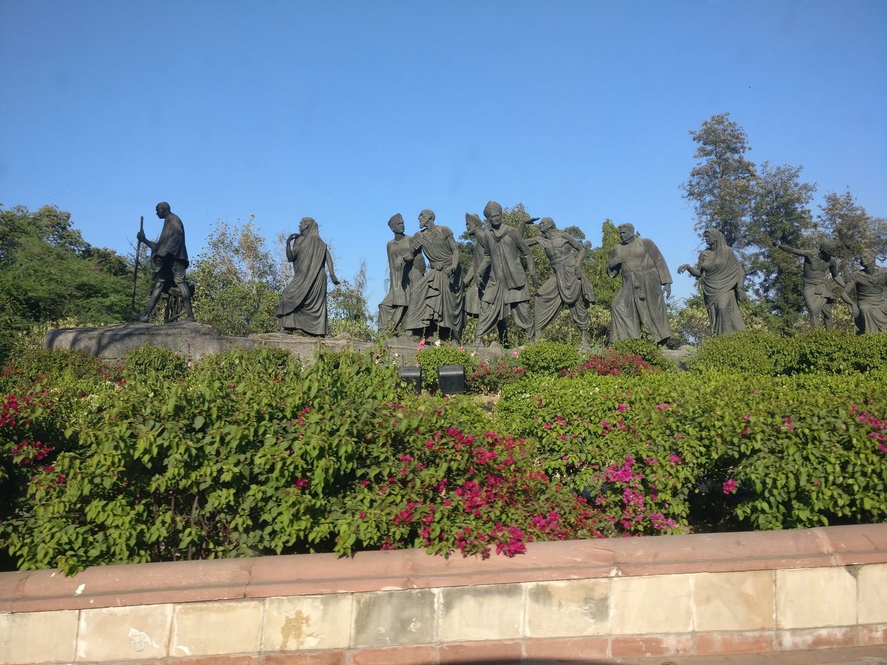 STATUE AGAINST TREES AND PLANTS AGAINST SKY