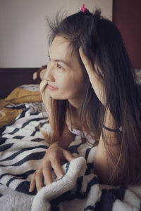 Portrait of woman relaxing on bed at home