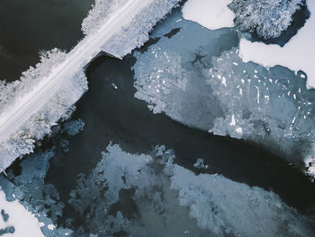 High angle view of person paddleboarding in lake during winter