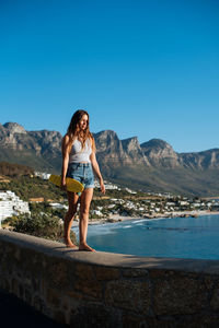 Full length of woman against mountains against clear blue sky