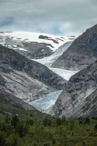 Scenic view of glacier and mountain range against sky