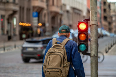 A city crossing with a semaphore on blurred background with cars in the evening streets, red light