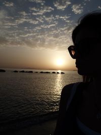 Portrait of man wearing sunglasses against sea during sunset