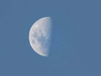Low angle view of moon against clear blue sky