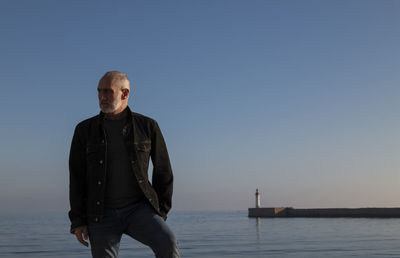 Adult man against sea and sky with lighthouse in background. almeria, spain