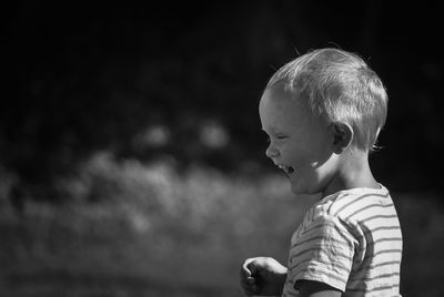 Sunlight falling on boy laughing while looking down