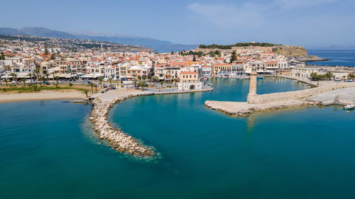 High angle view of townscape by sea against sky