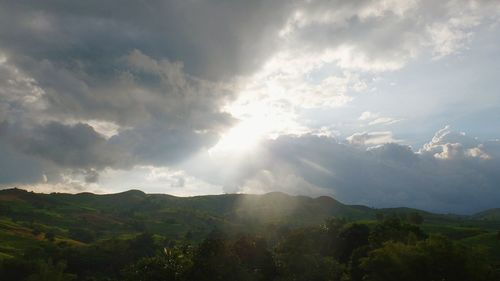 Scenic view of mountains against cloudy sky