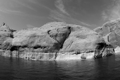 Rock formation in sea against sky