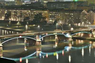 View of illuminated bridge over river at night