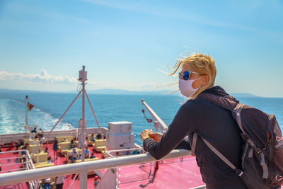 Woman wearing sunglasses on sea against sky