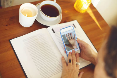 Midsection of woman using mobile phone on table