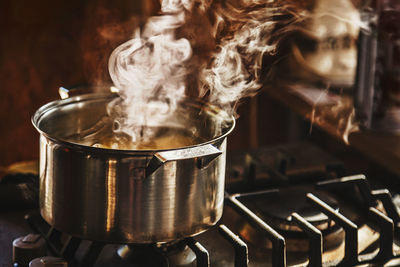 Atmospheric shot of beautiful clouds of steam rising from water boiling in a stainless steel cooker