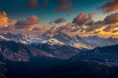 Aerial view of snowcapped mountains against sky during sunset