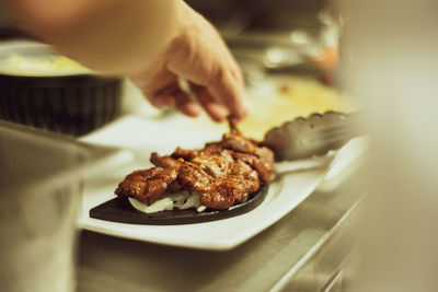 Close-up of person preparing food in plate